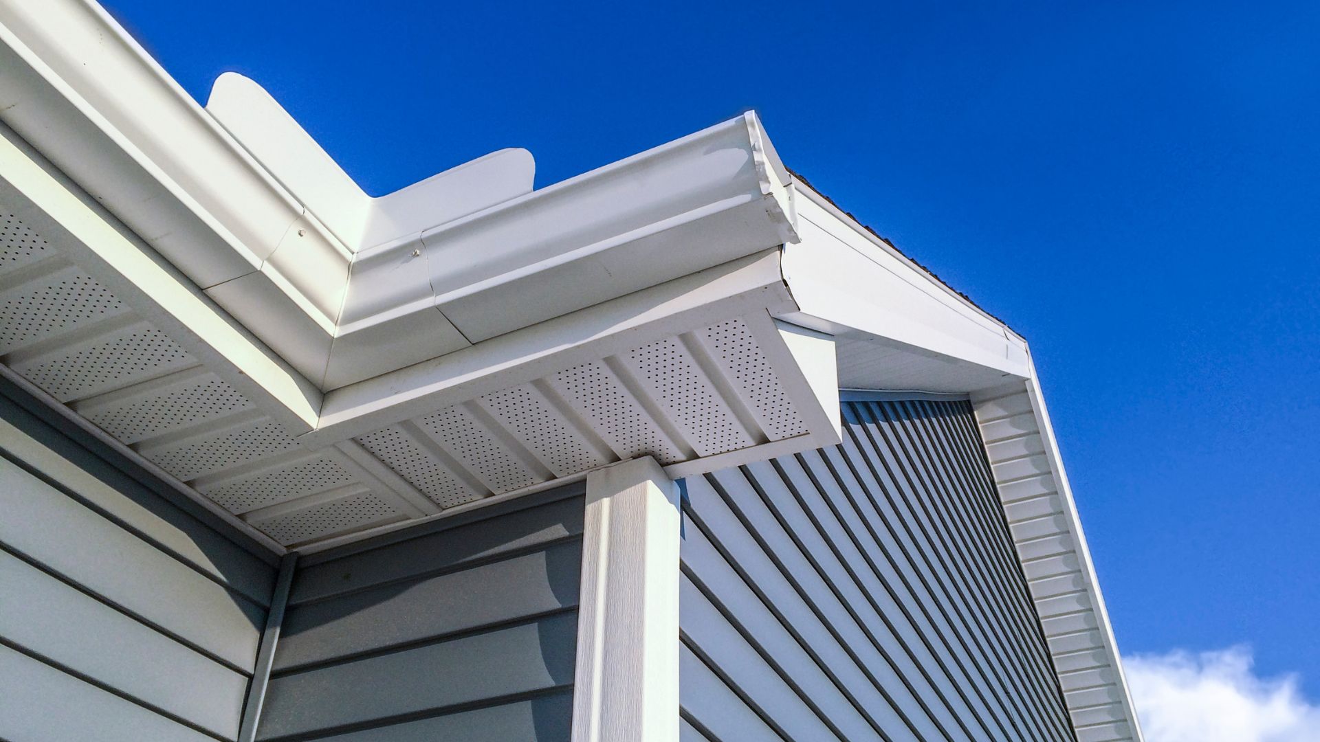 White modern architectural roof detail against bright blue sky