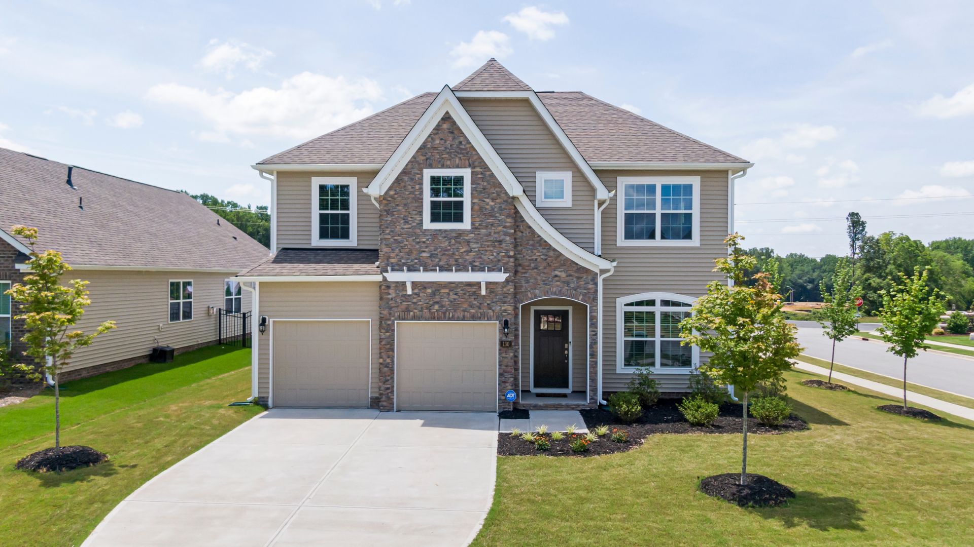 Two-story suburban house with stone facade and two-car garage