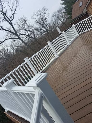 Wooden deck with white railings on a winter day with bare trees